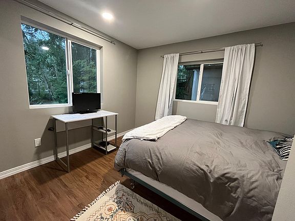 Bedroom with queen pillow top bed, new sheets, comforter with cover, and pillows.