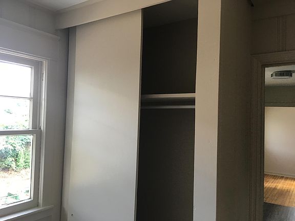 Bedroom with closet, lots of natural light in windows, preserved wood flooring. Neutral paint suits any decorator's taste.