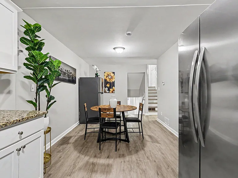Eat-in kitchen area with a dining table, ample cabinetry, and full-size refrigerator for everyday meal prep and storage.