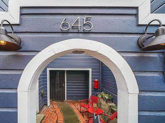 Come home through this cute archway, along a brick path, red furniture pictured is included.
