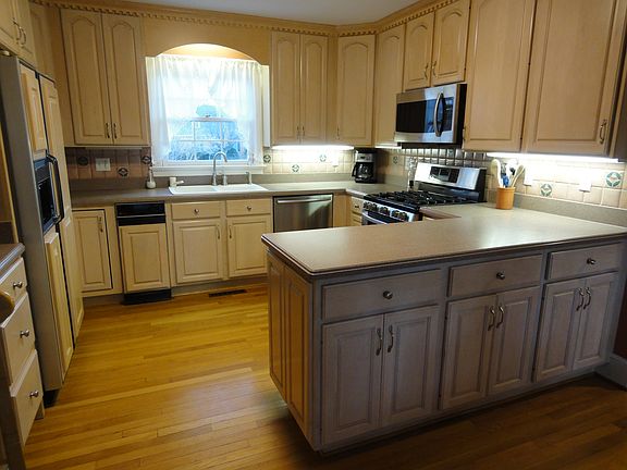 Kitchen with hardwood floors and tons of 42" cabintry, corian, s/s appliances