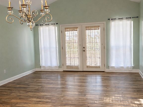 Photo of the living room in the background along with the french doors. The dining area is in the foreground.