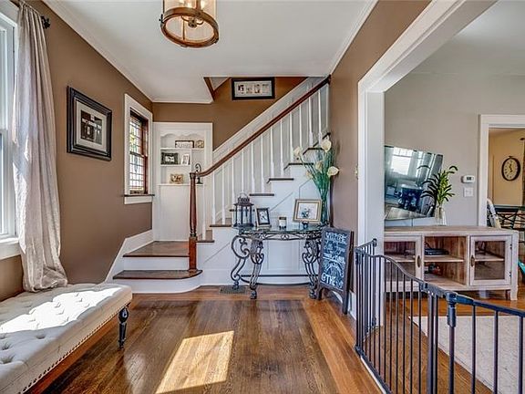 Welcoming Foyer with original stained glass window, woodwork and custom built-in.