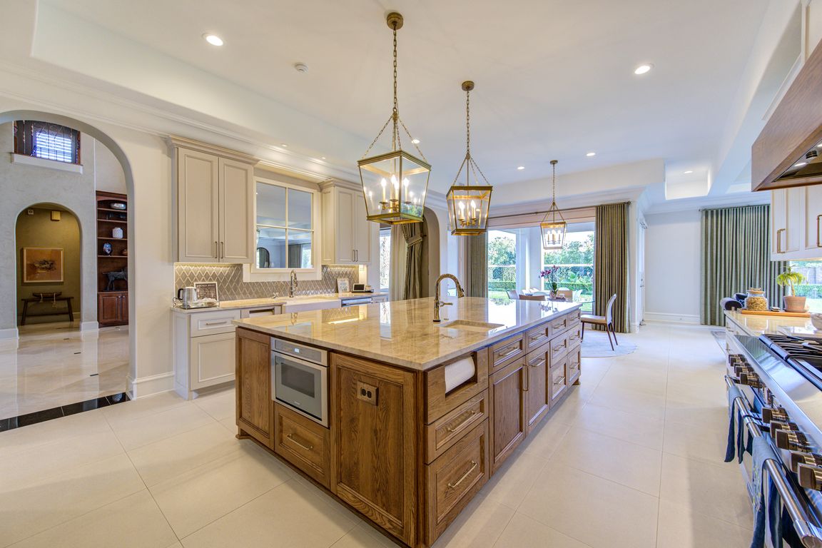 The chef’s kitchen is a showpiece: a solid oak center island steals the spotlight, surrounded by quartzite countertops, Sub-Zero and Thermador appliances, and custom cabinetry. Sophisticated, functional, and flawless for culinary creativity.