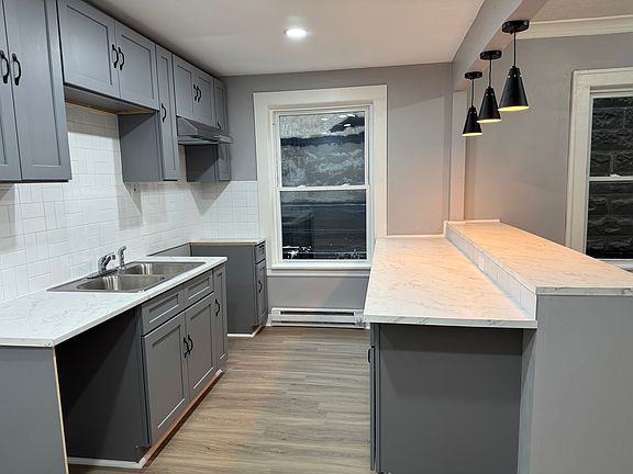 Stylish gray cabinetry, marble-look counters, and updated lighting.