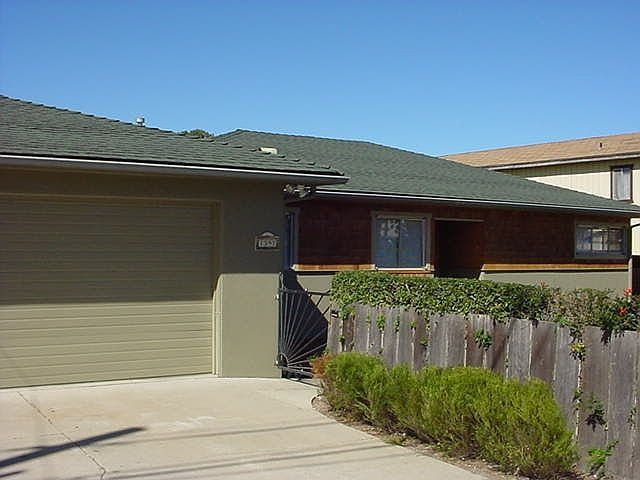The fenced front yard of this large corner lot creates a courtyard entry.
