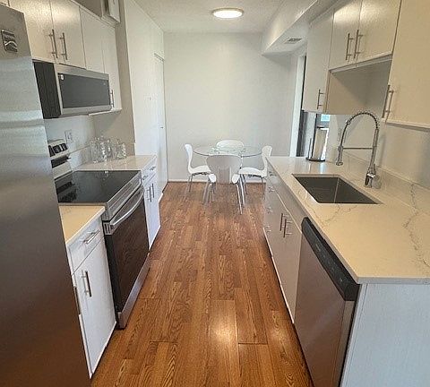 Completely renovated eat in kitchen with stone counter, square modern sink/faucet and all stainless steel appliances. Enclosed sunroom off the kitchen for more space and views.