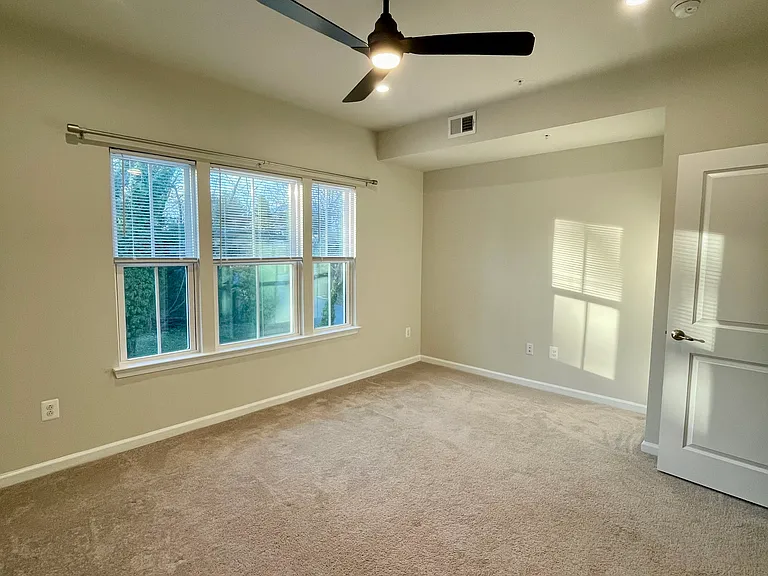 Light-filled primary ensuite with sitting area and ceiling fan