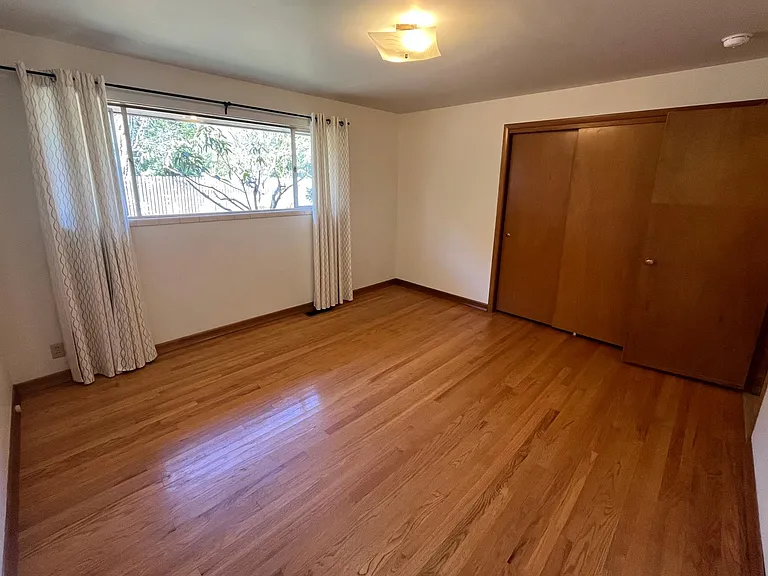 Bedroom 2 with hardwood floor and closet.