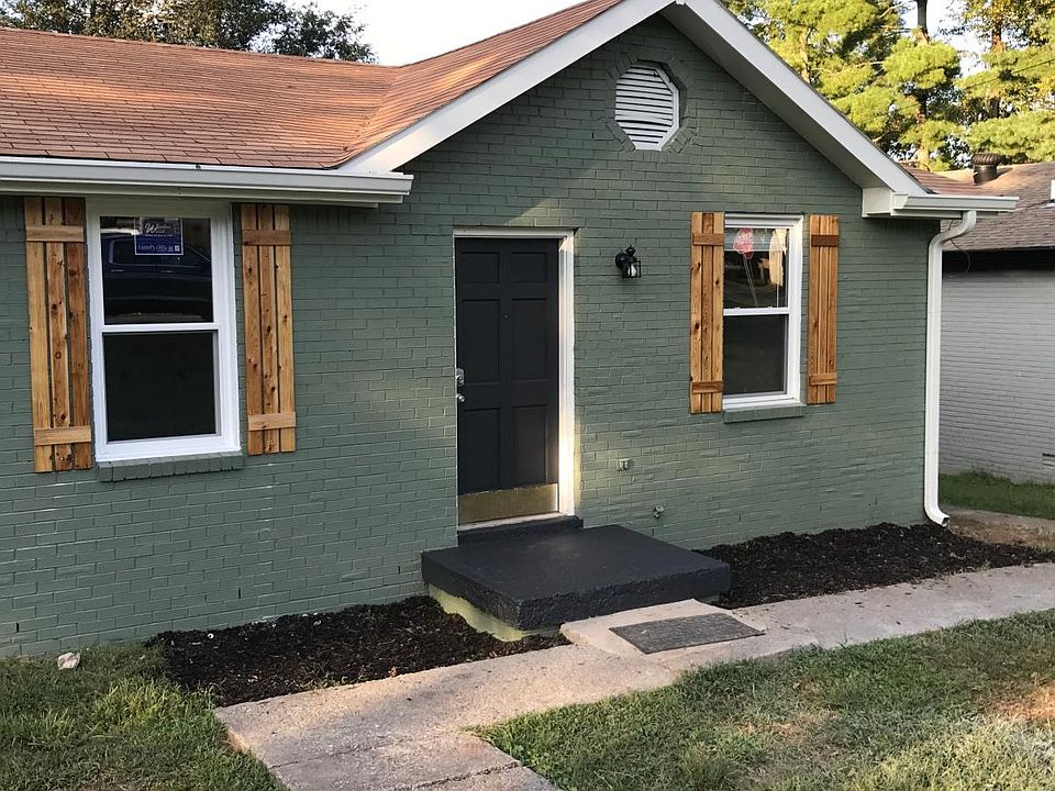 Adorable painted brick and cedar shutters give the home curb