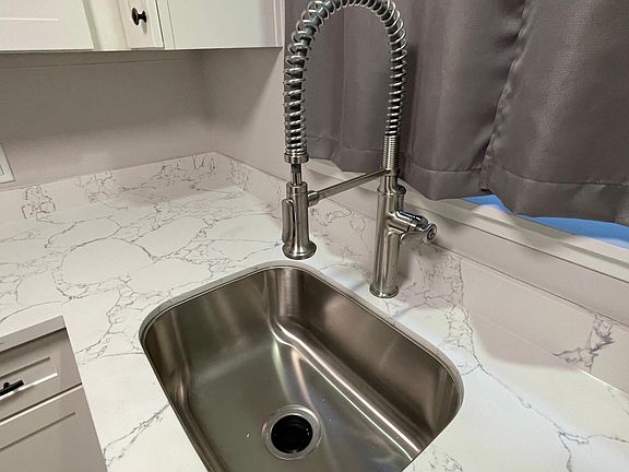 brand new quartz countertops, stainless steel sink, and large faucet.