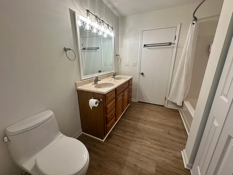 Another view of the large bathroom. The closed door leads to the hallway, the double door on the right leads to the laundry space.