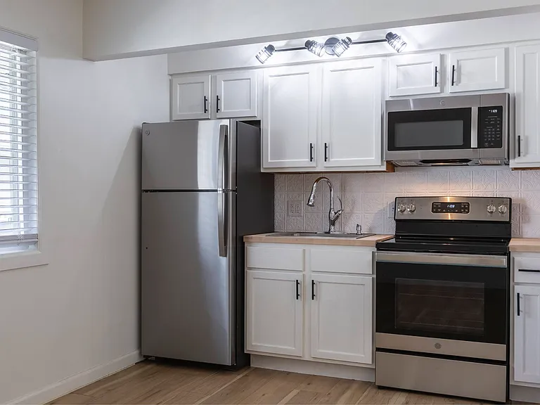 White cabintes in a kitchen at Cuming St. Apartments.
