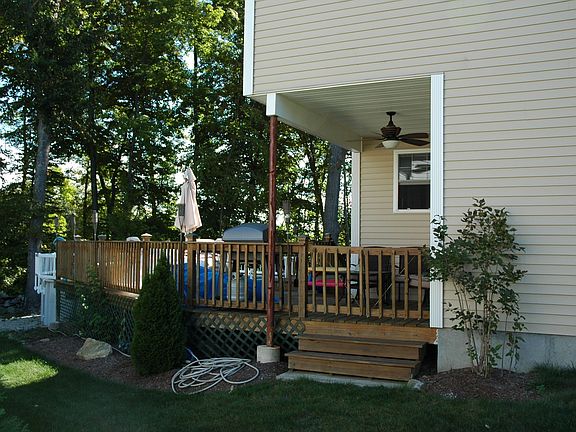 Expansive deck attached to Above Ground Pool with enclosure and ceiling fan