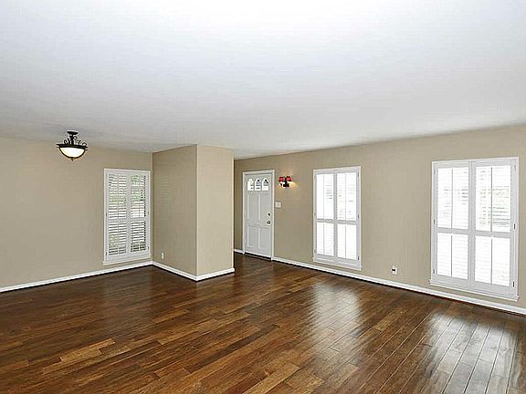 Another view of the spacious living room with plantation shutters & an abundance of natural light.