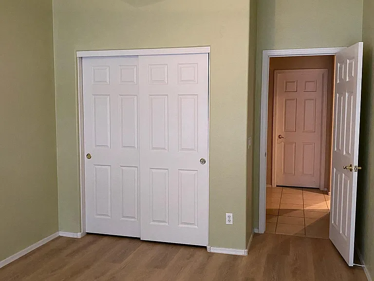 Bedroom 2. Plantation shutters, Hunter ceiling fan with light, brand new L.V.P. laminate flooring and fresh paint. Picture taken November 16, 2023 afternoon.