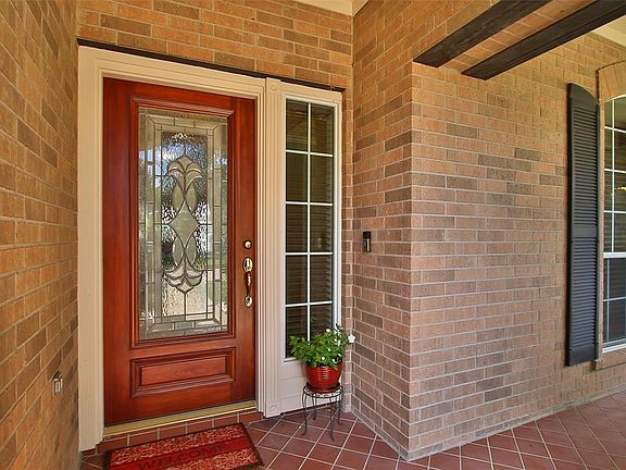 Solid wood door with lead glass insert for that custom feel. Sidelight window with blinds for privacy. Ring brand doorbell.