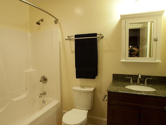 Bathroom with tile floor, granite countertop, and cherry and