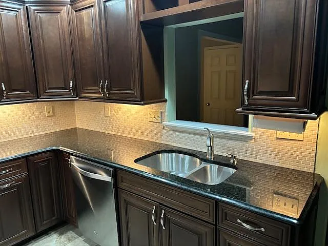 Dishwasher. Undercabinet lights. Passthrough window looking into the living room and front hall.