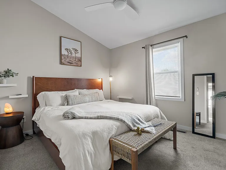Primary bedroom with extra large closet, blackout curtains, ceiling fan, top of the line mattress and bedding supplied. Vaulted ceiling gives the feel of great spaciousness.