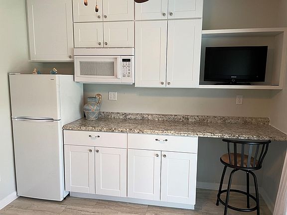 Kitchenette includes new refrigerator/freezer, microwave, electric appliances: toaster/oven, skillet, crockpot, coffee pot, dishes, and silverware included, plus coutertop work space, bar stool and small TV.