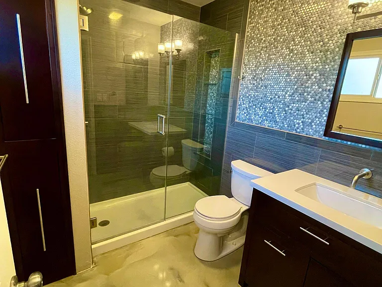 invisible glass shower doors in this beautiful tile en suite