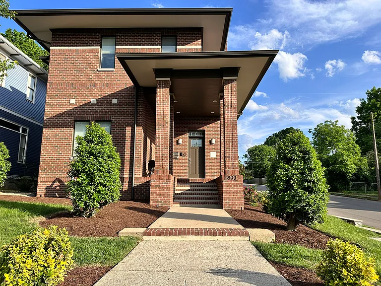 This impressive walkway if off of Fatherland St. and leads to the covered porch with the mailbox, outdoor camera and the keyless entry front door.