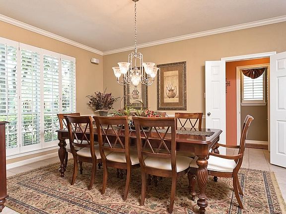 The dining room has ceramic tile, plantation shutters, crown and chair moulding, and an upgraded chandelier.