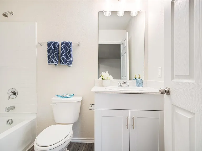 Bathroom featuring a vanity with an undermount sink, a white countertop, and a matching white cabinet with silver pulls