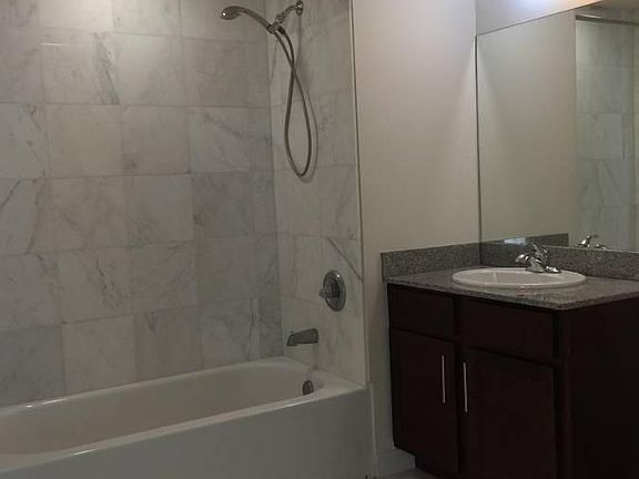 Spacious bathroom with marble floor and walls. Elegant soaking tub.