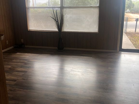 Living area with large sunny windows overlooking front porch.