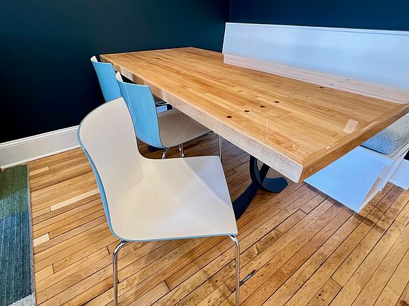 Dining area featuring banquette seating, two-tone Italian chairs, and yes, the maple table was formerly part of a bowling alley lane, complete with walnut aiming dots intact.