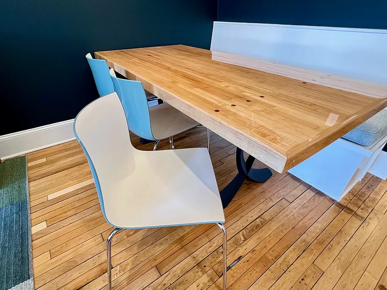 Dining area featuring banquette seating, two-tone Italian chairs, and yes, the maple table was formerly part of a bowling alley lane, complete with walnut aiming dots intact.