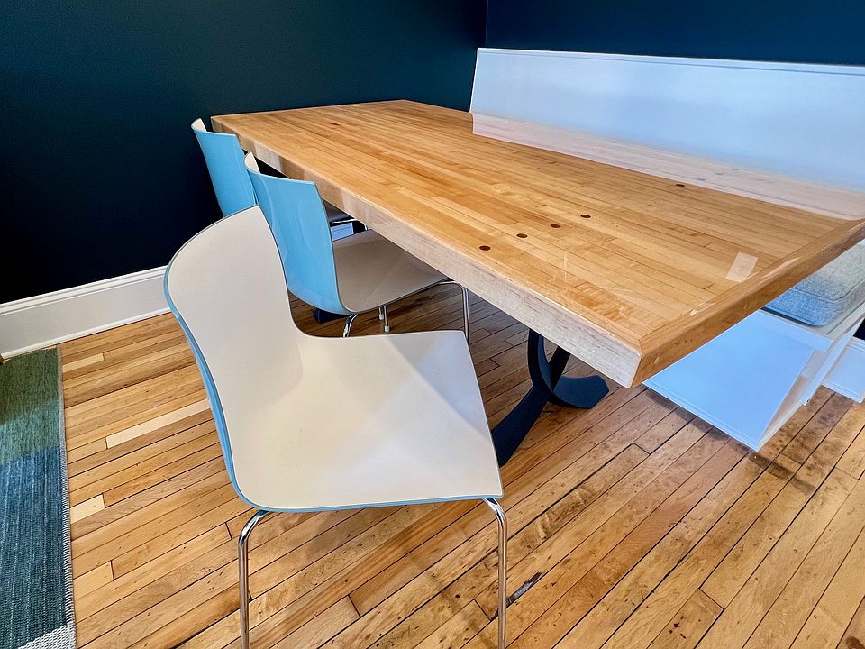 Dining area featuring banquette seating, two-tone Italian chairs, and yes, the maple table was formerly part of a bowling alley lane, complete with walnut aiming dots intact.