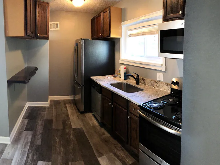 Stainless steel appliances, walnut live edge shelf and granite countertops complete an amazing kitchen