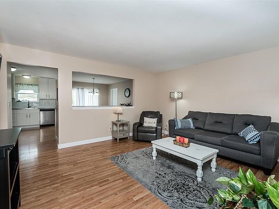 Living room with open cut out to kitchen to create a more open floor plant