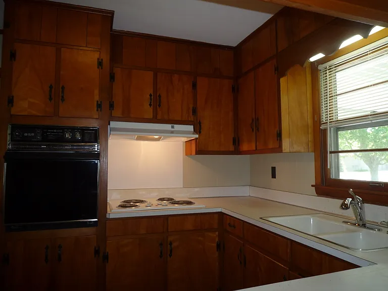Newer cook top and vent hood. We saved the enamel coated cast iron sink and original pine cabinetry. Retro at it's best.