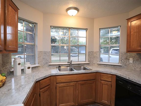 Light pours in the kitchenâs bay window which overlooks front yard. Notice the dual-bowl stainless steel sink with pull-out sprayer