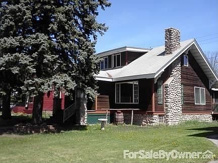Front of house
						:
						2 pines grace the front, stone fireplace and stone on bottom of cedar siding.
