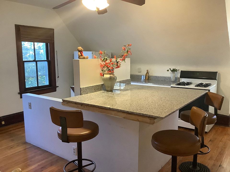Large granite island in kitchen above staircase