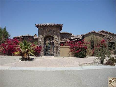 Semi-custom stone faÃ§ade entry rotunda, with Tuscan wrought iron works, and circular paver driveway.