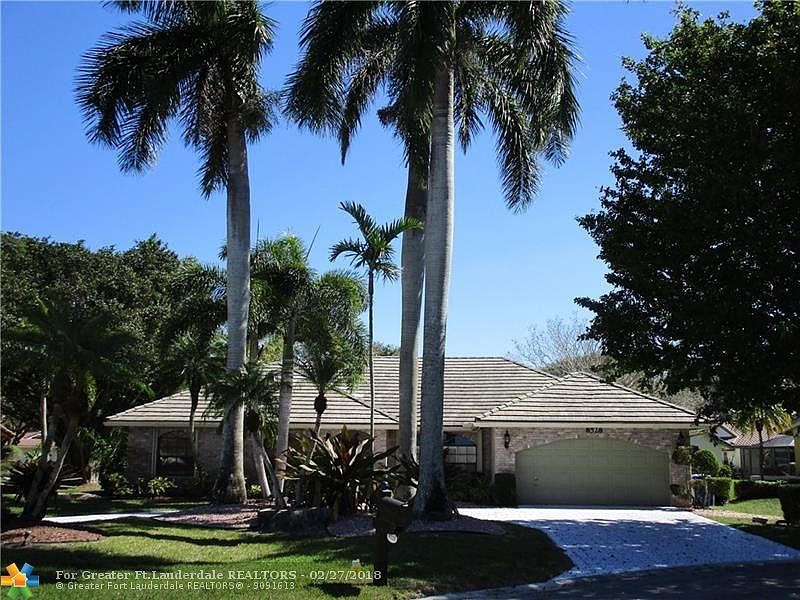 Meticulous and Manicured Home situated on cul de sac location with circular driveway and majestic Royal Palms