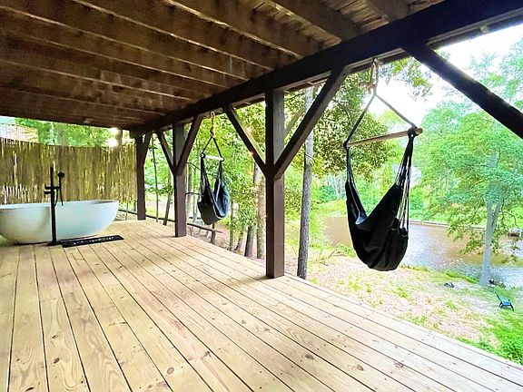 the lower deck with hammock chairs and soaking tub overlooking lake
