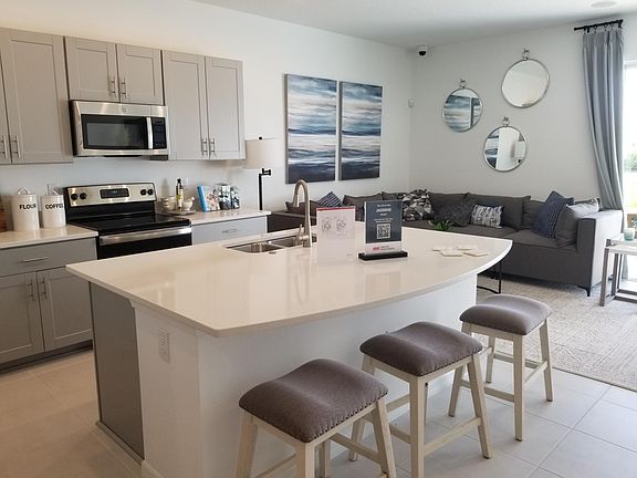 Open-concept kitchen living area of the model home of the same townhouse plan, Jasmine