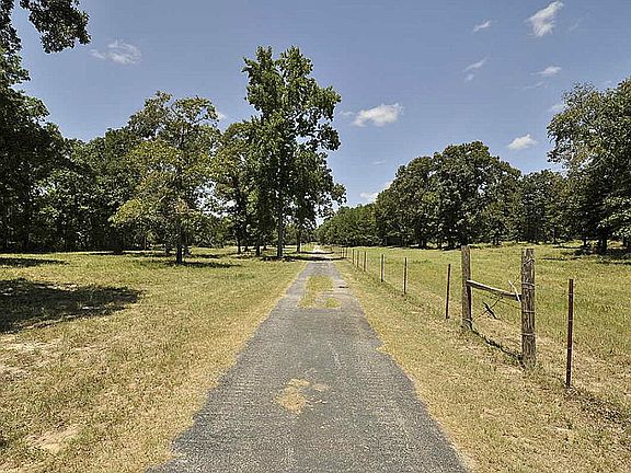 Half mile drive to home is all asphalt! Never need to get your vehicle dirty!Ranch is located a short 6.7 miles from I-45!  Much of the drive is four lanes!  Gate necessary to enter the property!This picture is just beyond the gate.