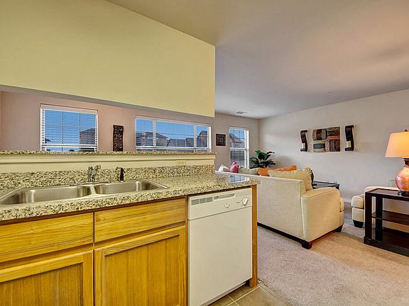 A kitchen with lots of cabinet storage, double sinks, and granite countertops