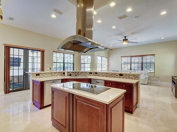 Kitchen island with glass cooktop, overhead exhaust hood, 2 dishwashers