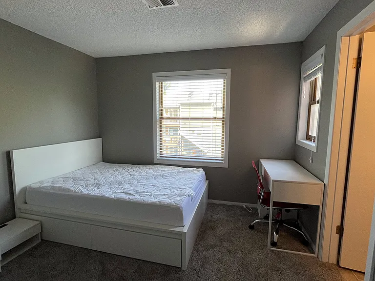 Master bedroom with plenty of space includes a double-size bed and a desk, as well as a private bathroom.