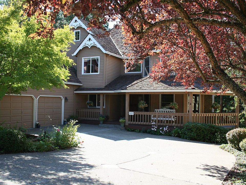 Inviting covered front porch wraps around the front of the house