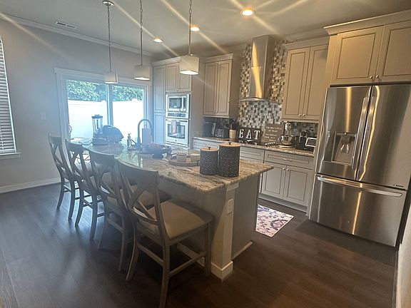 Kitchen area with large quartz island and soft close cabinets.